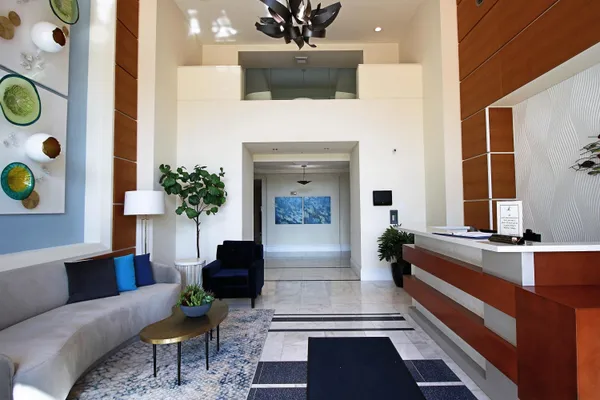 a view of a swimming pool with a lawn chairs under palm trees