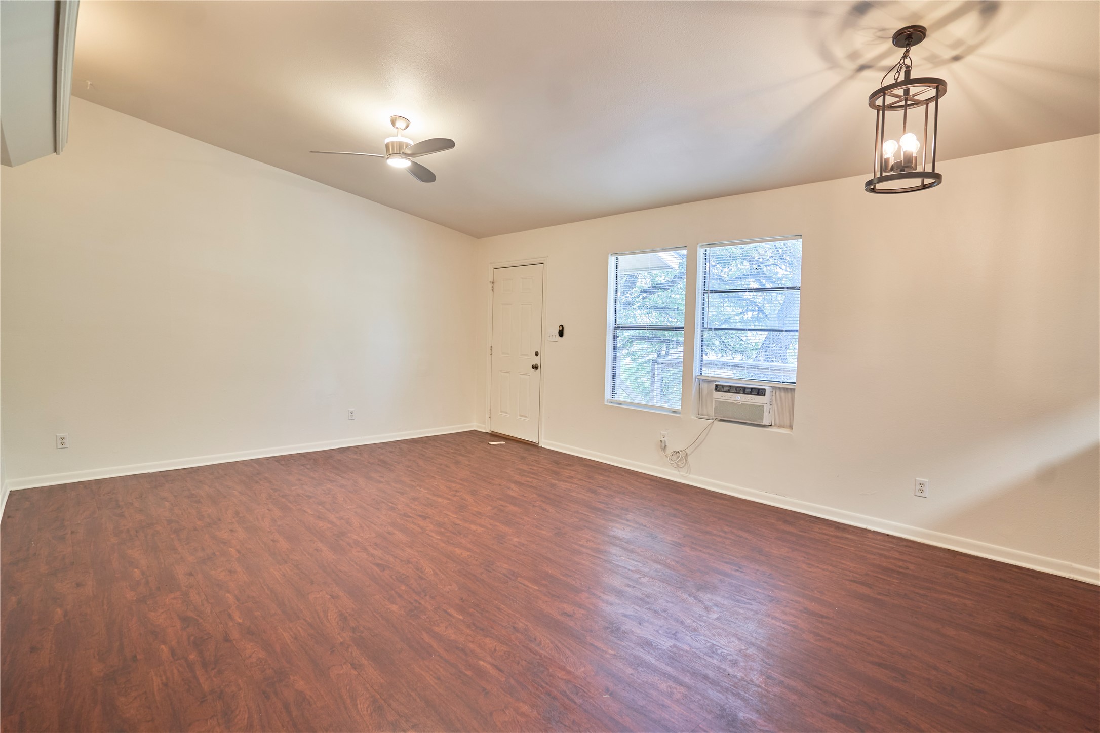 23393 Nameless Road, Unit 171 Leander, TX 78641 - Photo 8 of 15 A versatile living space with rich wood-look flooring and multiple light fixtures awaits personalization.