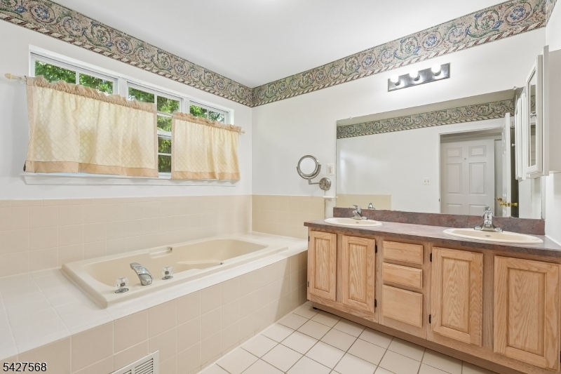 1 Leigh Road Hillsborough, NJ 08844 - Photo 25 of 35 a bathroom with a tub a sink and a large mirror