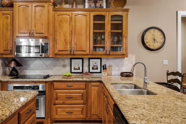 a kitchen with stainless steel appliances granite countertop a stove a sink and a microwave