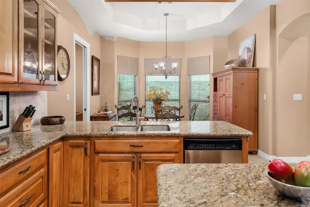 a kitchen with stainless steel appliances granite countertop a sink a counter space and cabinets