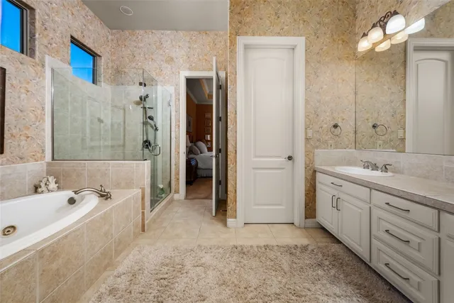 a spacious bathroom with a tub sink and mirror