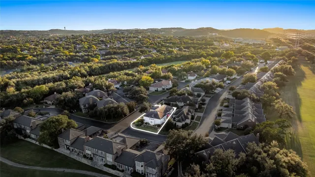 an aerial view of residential house with parking and trees