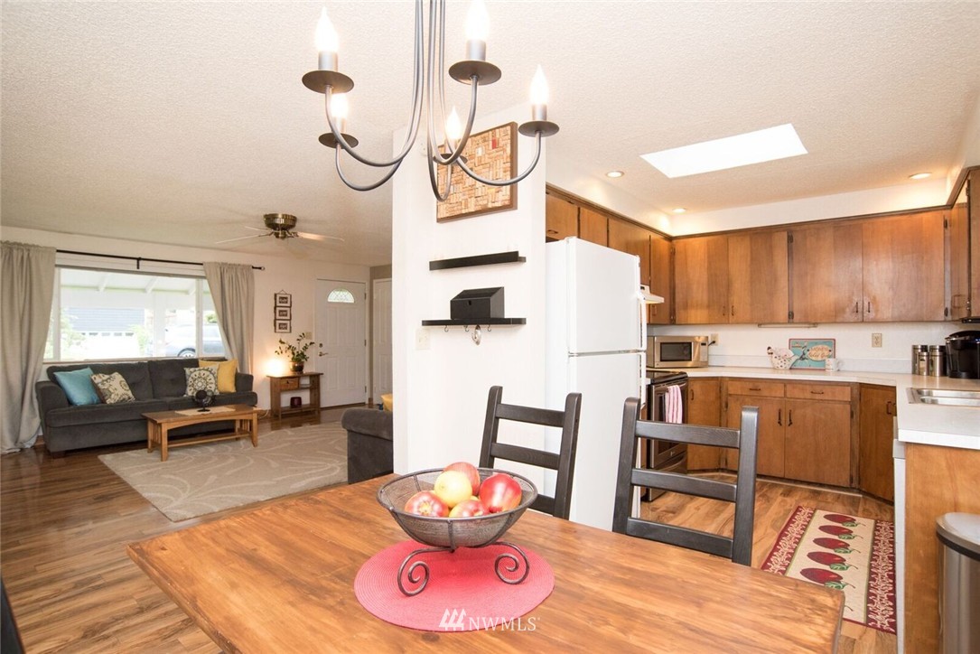 11510 Southeast 178th Place Renton, WA 98055 - Photo 7 of 18 a living room with stainless steel appliances furniture a rug and a dining table