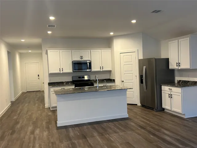 a kitchen with stainless steel appliances a refrigerator and a stove top oven