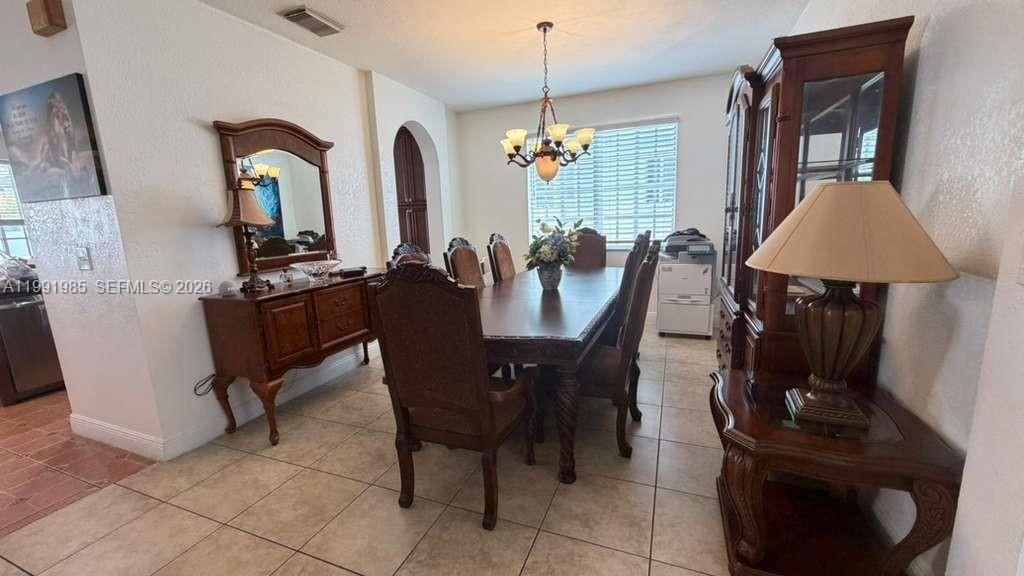 14065 Southwest 278th Street Homestead, FL 33032 - Photo 12 of 30 a view of a dining room with furniture and chandelier