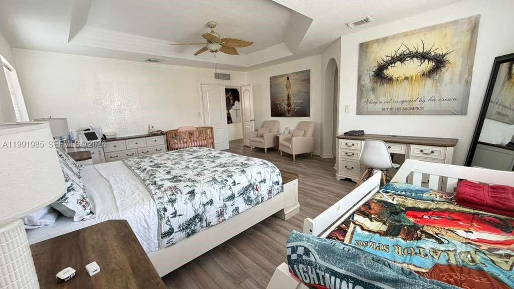 14065 Southwest 278th Street Homestead, FL 33032 - Photo 19 of 30 a bedroom with a bed and a chandelier