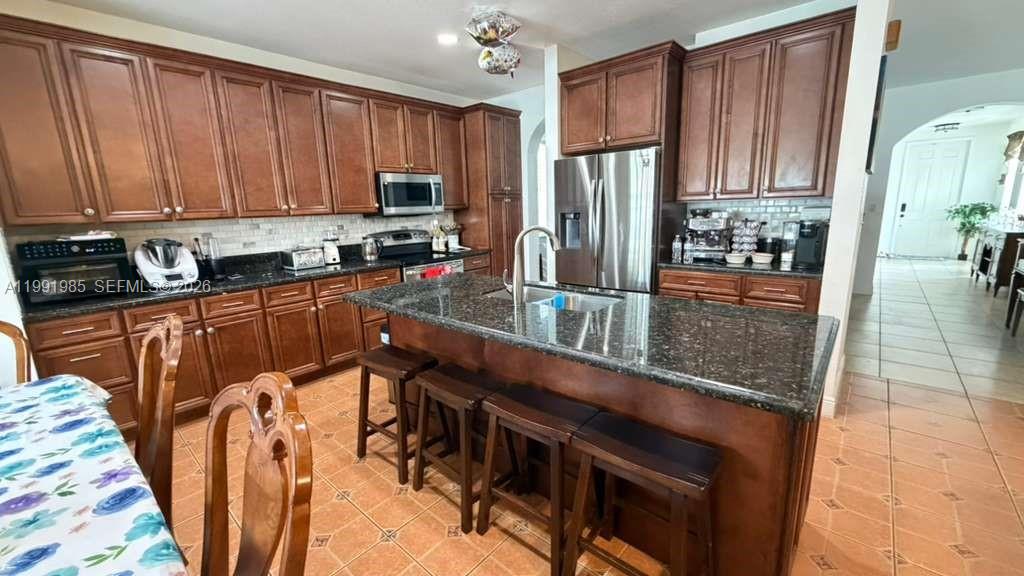 14065 Southwest 278th Street Homestead, FL 33032 - Photo 5 of 30 a kitchen with stainless steel appliances granite countertop a refrigerator a stove top oven with a sink and dishwasher