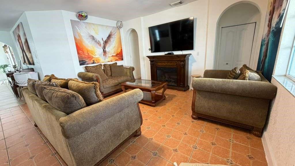 14065 Southwest 278th Street Homestead, FL 33032 - Photo 6 of 30 a living room with furniture a flat screen tv and a fireplace