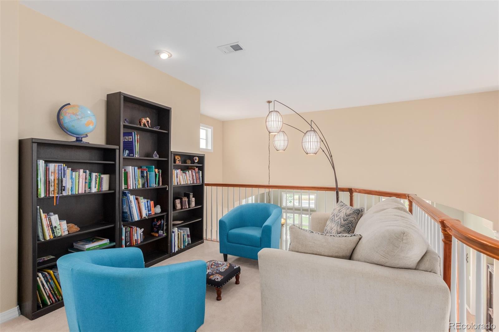 21923 East Ridge Trail Circle Aurora, CO 80016 - Photo 26 of 40 a living room with furniture a rug and a book shelf