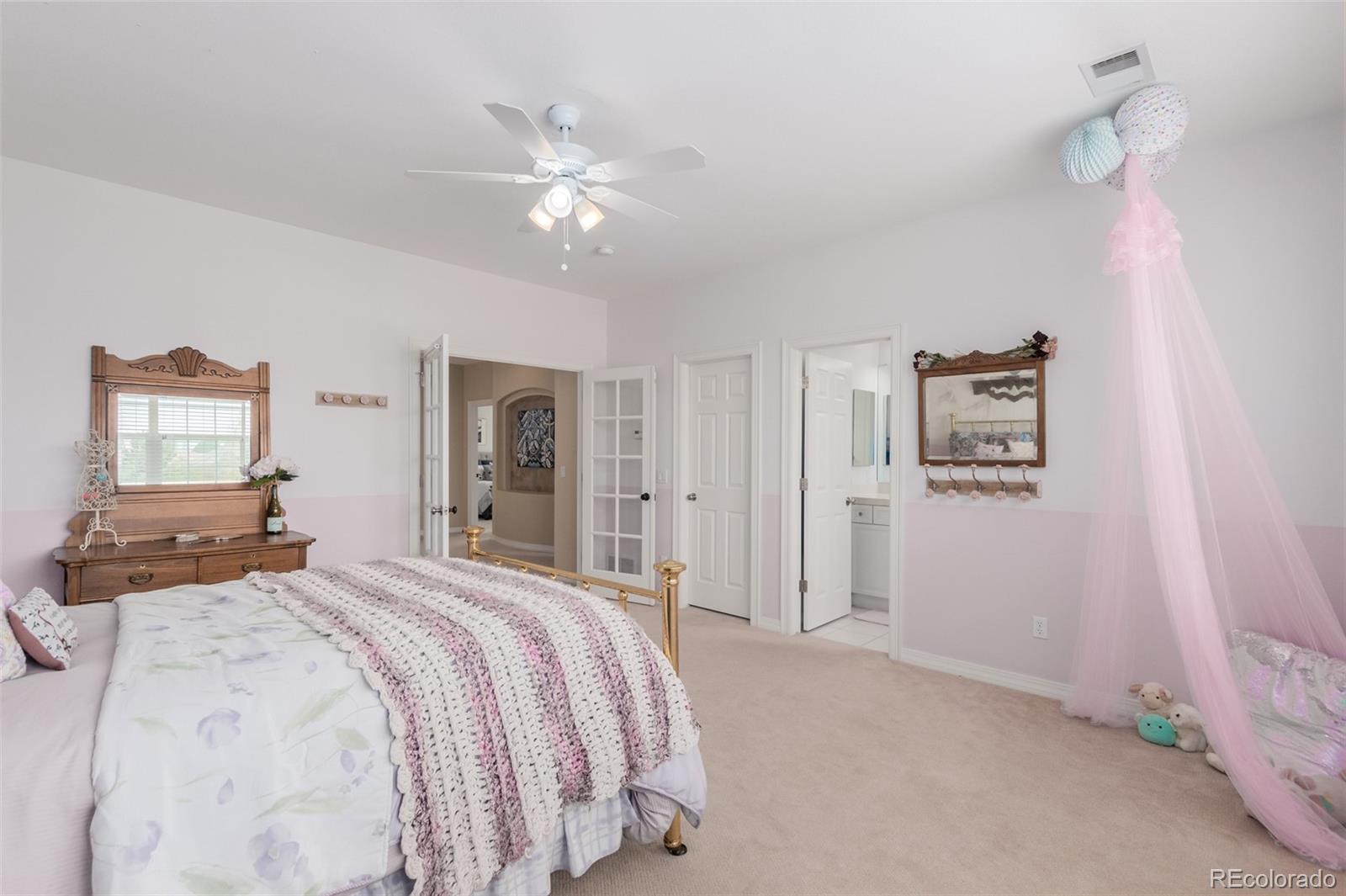 21923 East Ridge Trail Circle Aurora, CO 80016 - Photo 27 of 40 a bedroom with a bed and a chandelier