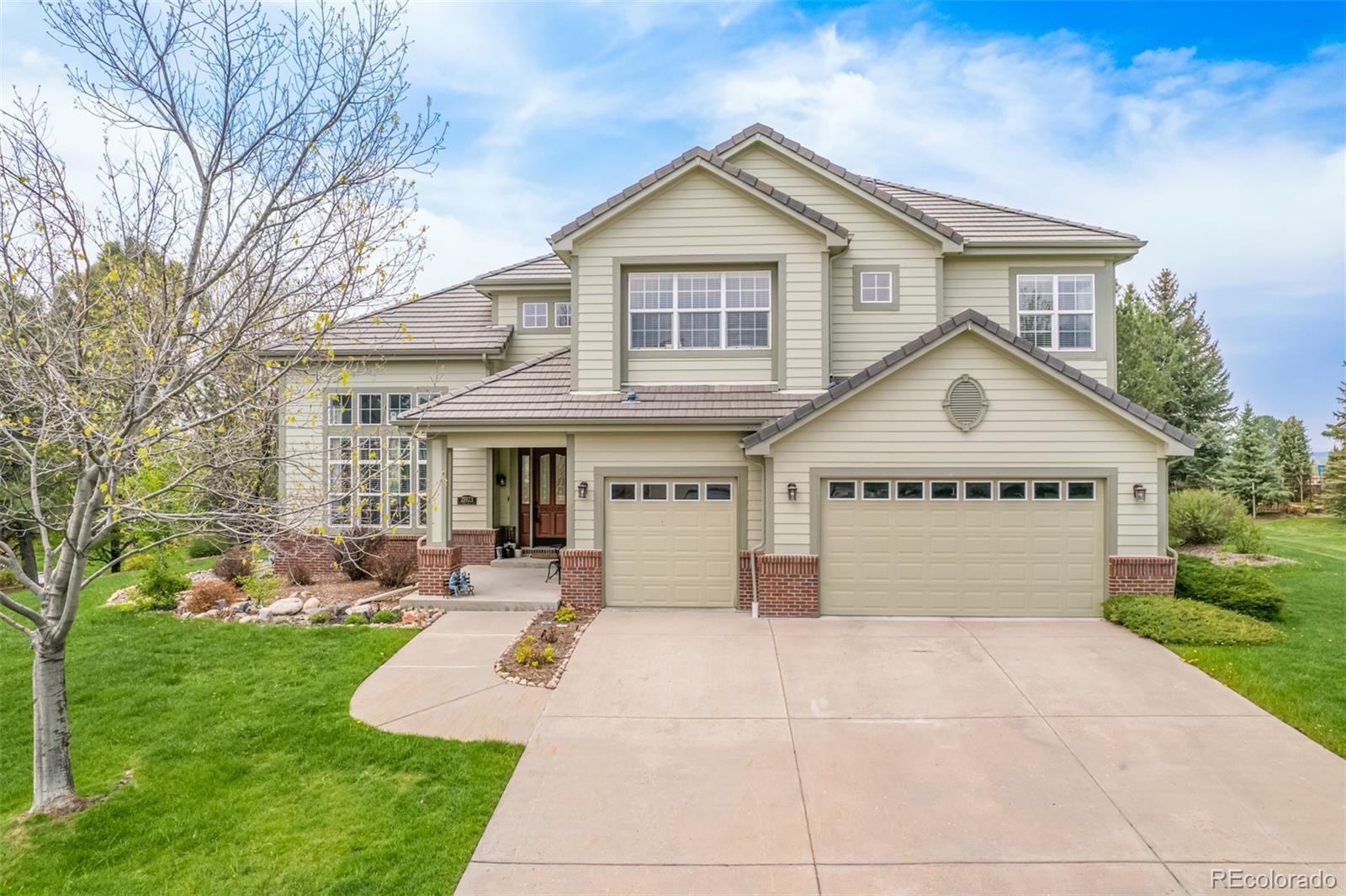 21923 East Ridge Trail Circle Aurora, CO 80016 - Photo 29 of 40 a view of a white house with a yard plants and large tree