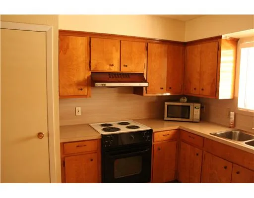 a kitchen with a sink a stove and a microwave