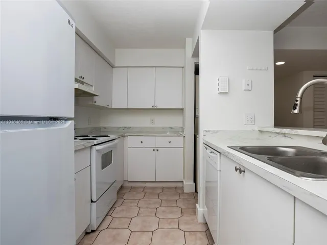 a kitchen with white cabinets and white appliances
