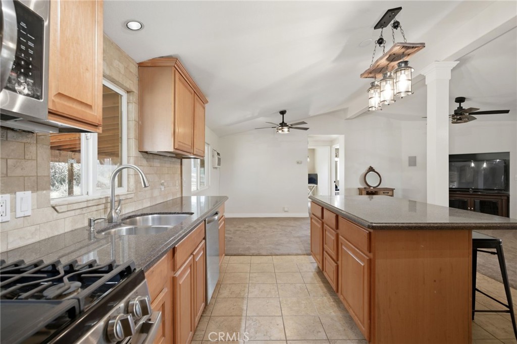 40100 Owl Valley Road Temecula, CA 92592 - Photo 25 of 44 a kitchen with stainless steel appliances a sink stove and cabinets