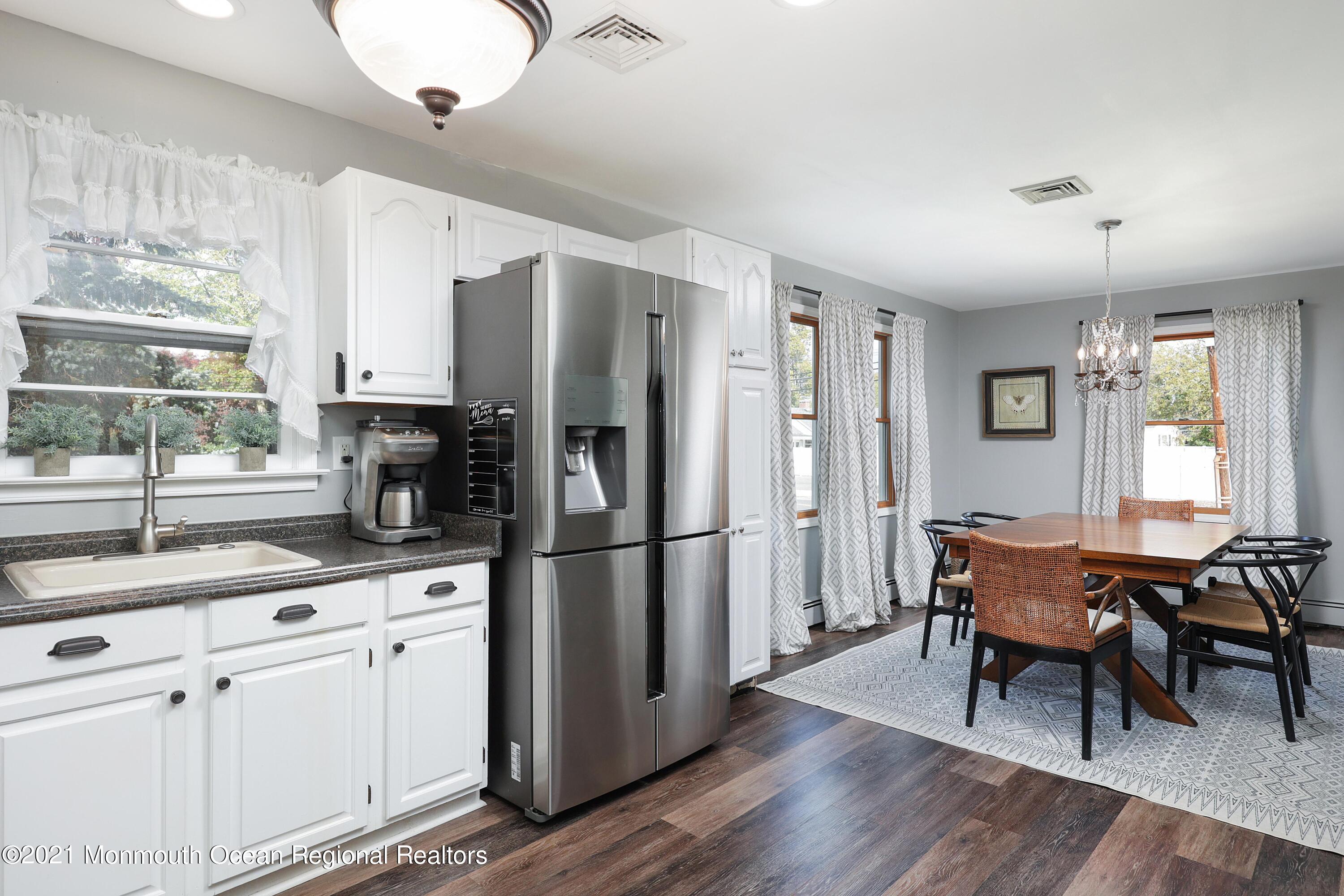 464 E Road Belford, NJ 07718 - Photo 14 of 25 a kitchen with stainless steel appliances granite countertop a refrigerator a sink dishwasher a dining table and chairs with wooden floor