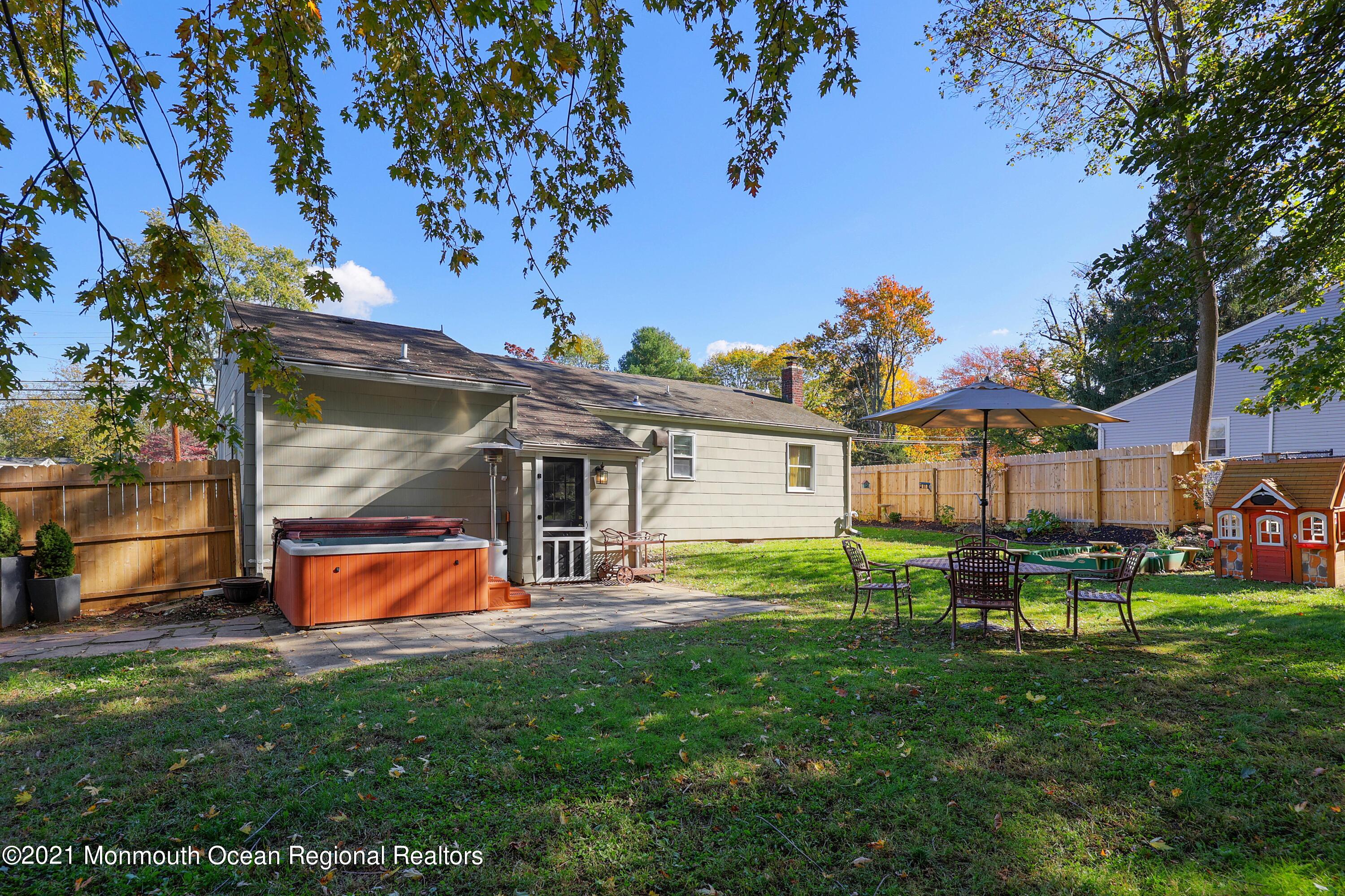 464 E Road Belford, NJ 07718 - Photo 22 of 25 a view of a backyard with table and chairs potted plants and large tree