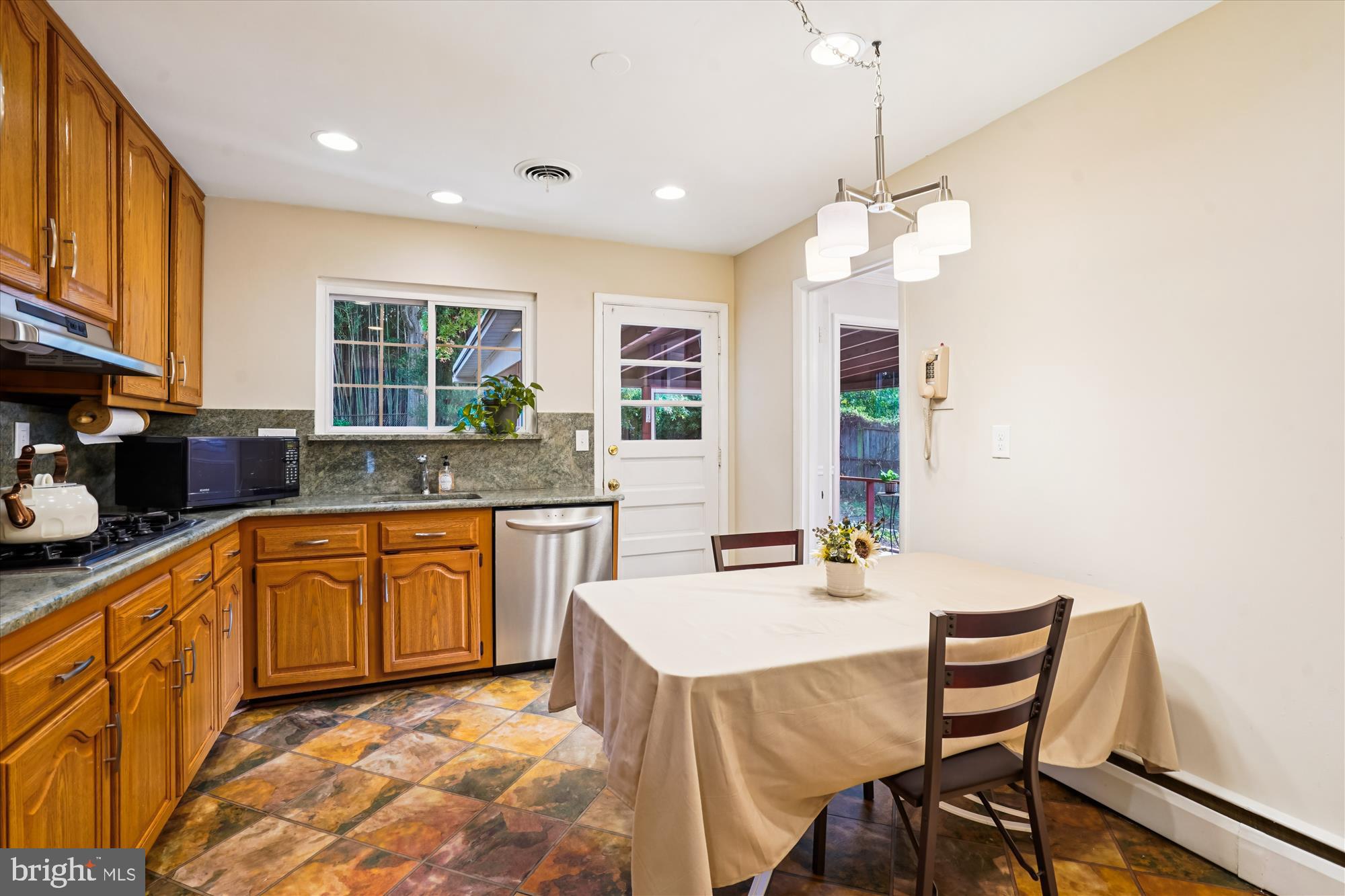 6216 Rockhurst Road Bethesda, MD 20817 - Photo 16 of 52 a kitchen with granite countertop a stove a sink a dining table and chairs