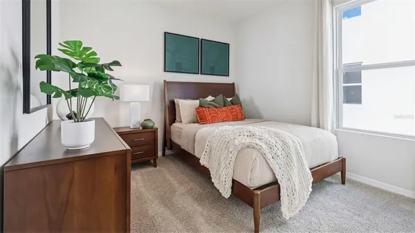 a bedroom with a bed table and a potted plant