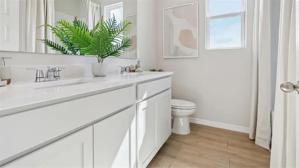 a bathroom with a granite countertop sink a toilet and mirror