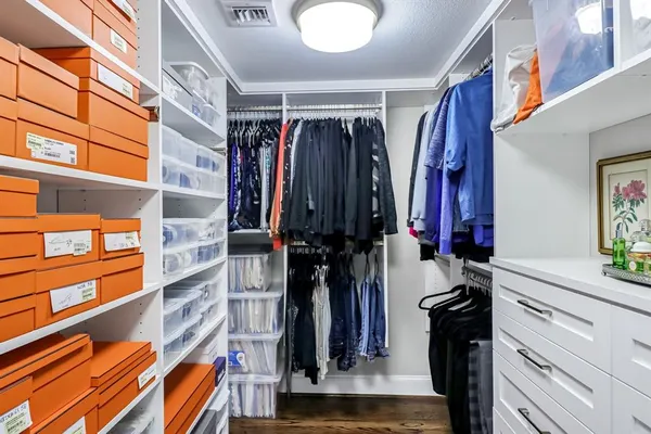 a view of walk in closet with clothes and shoes