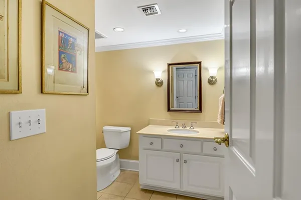 a bathroom with a toilet sink vanity and mirror
