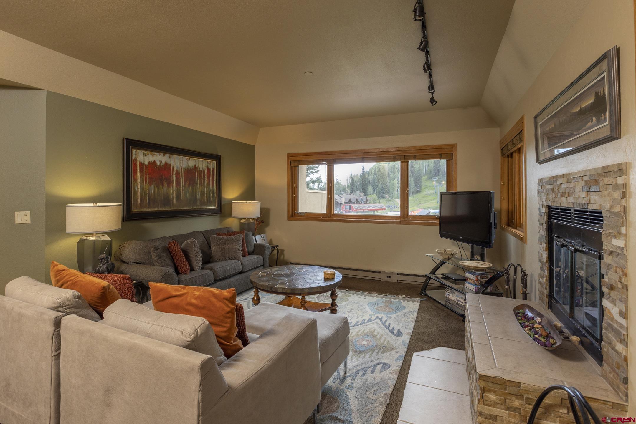 93 Needles Way, Unit 413 Durango, CO 81301 - Photo 2 of 31 a living room with furniture a fireplace and a flat screen tv
