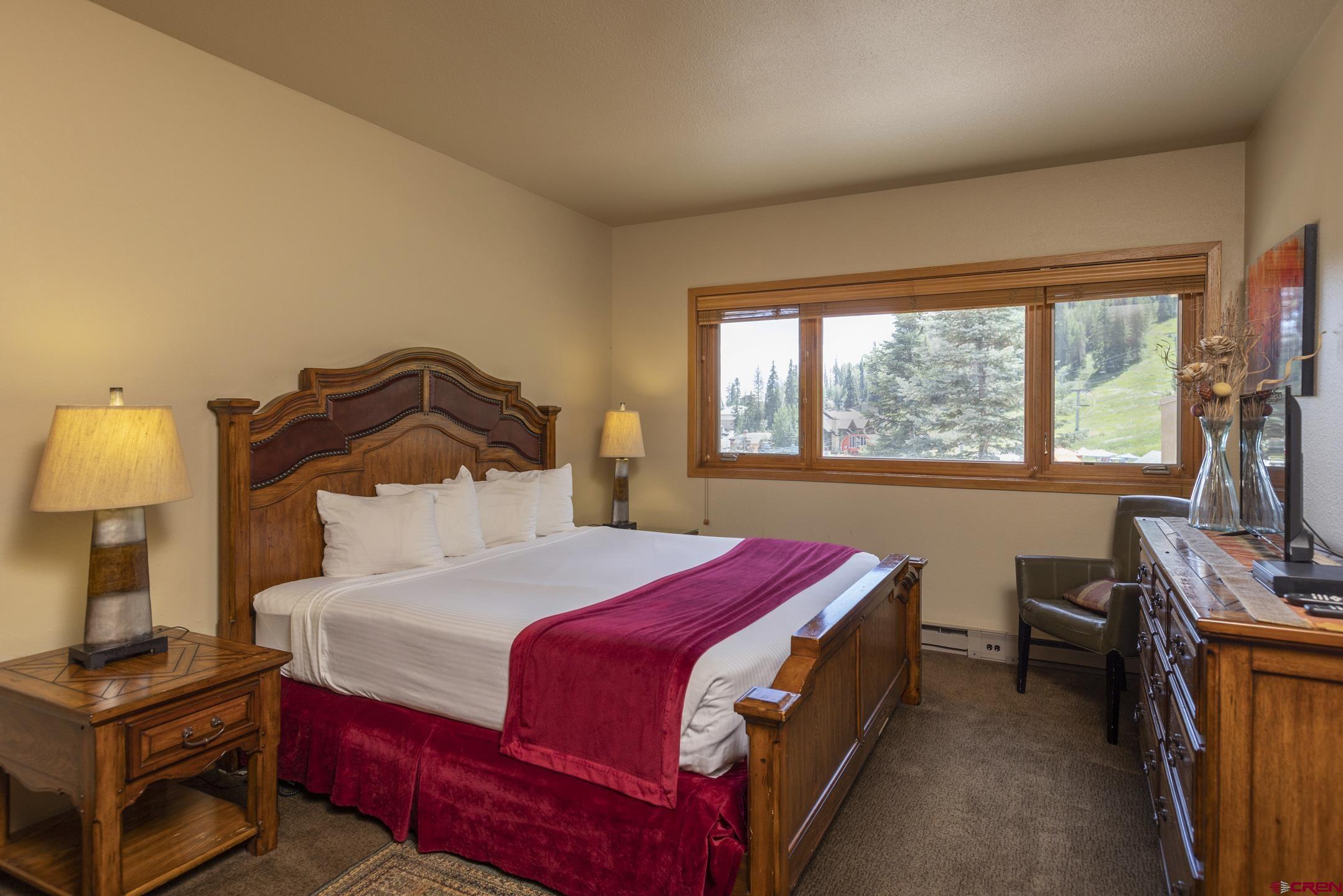 93 Needles Way, Unit 413 Durango, CO 81301 - Photo 9 of 31 a bedroom with a bed next to a window with a dresser