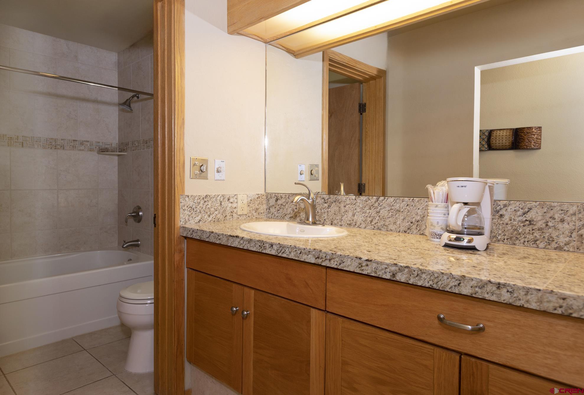 93 Needles Way, Unit 413 Durango, CO 81301 - Photo 10 of 31 a bathroom with a granite countertop sink a toilet and shower
