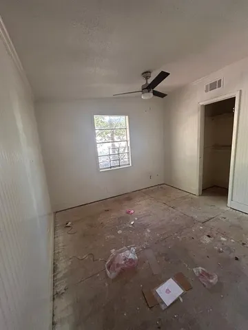 an empty room with windows and ceiling fan view
