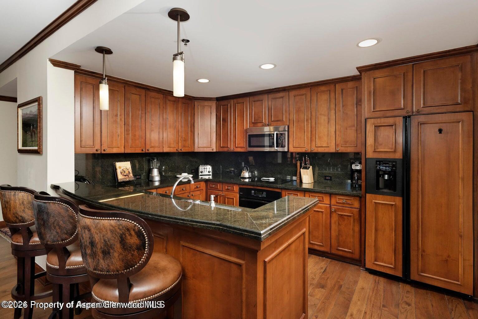 39 Boomerang Road, Unit 841119 Aspen, CO 81611 - Photo 3 of 18 a kitchen with stainless steel appliances granite countertop a stove sink refrigerator and cabinets