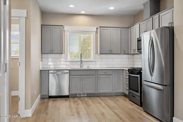 a kitchen with granite countertop a refrigerator sink and cabinets