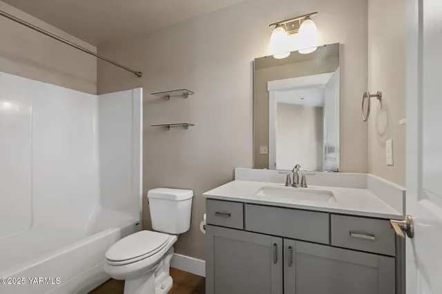 a bathroom with a sink toilet vanity and shower