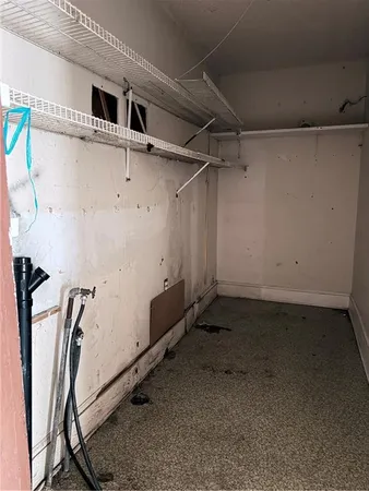 an empty room with wooden floor cabinet and windows