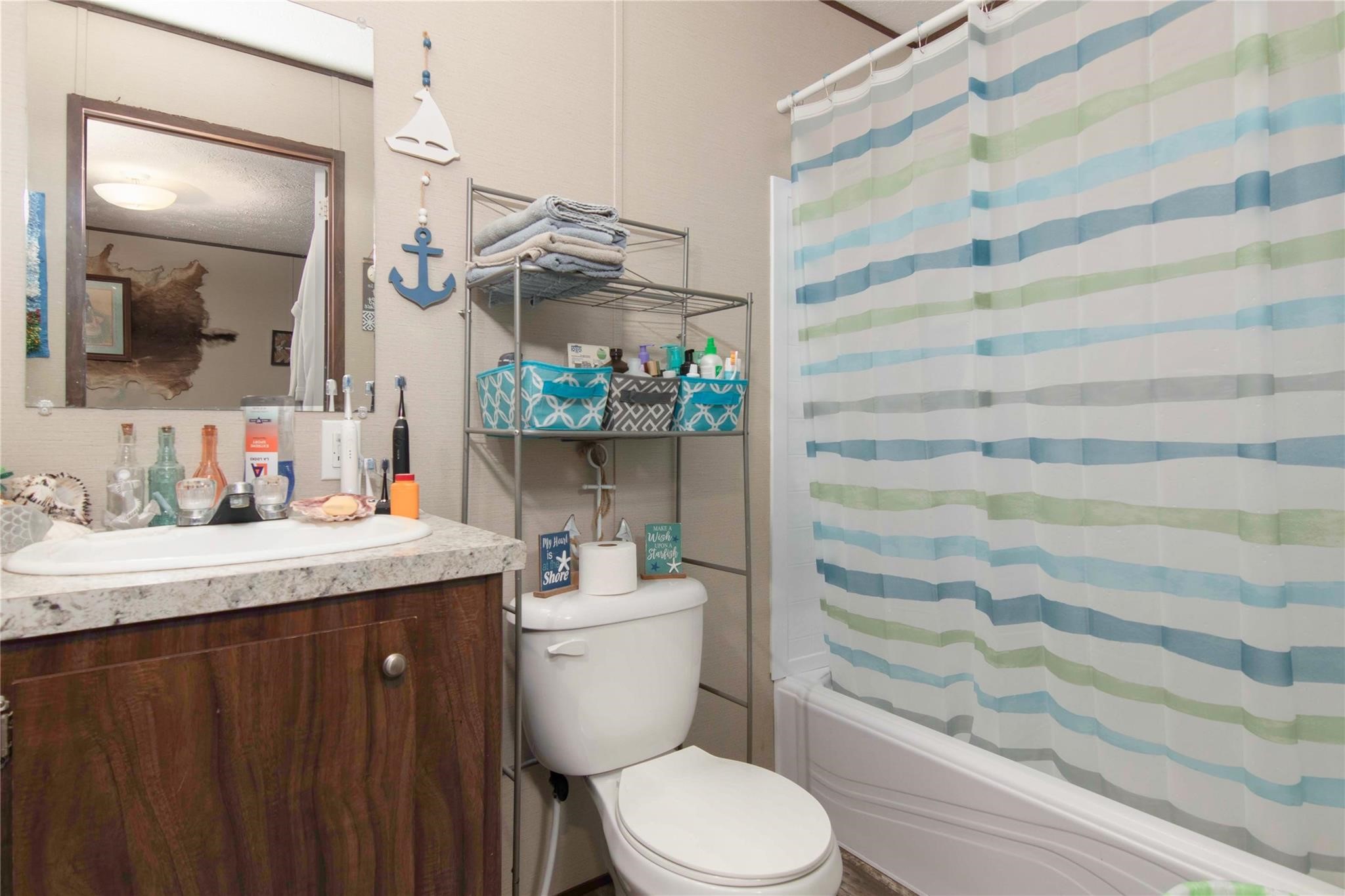 18093 Pickering Road Conroe, TX 77302 - Photo 21 of 29 a bathroom with a granite countertop sink toilet and shower