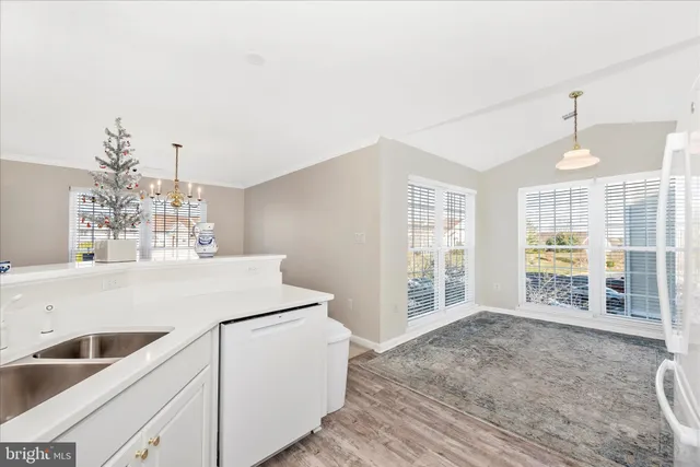 a kitchen with stainless steel appliances a sink cabinets and wooden floor