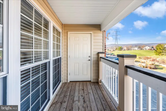 a view of a balcony with wooden floor and iron fence