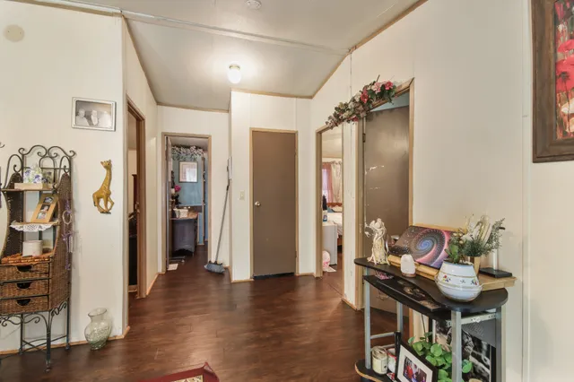 a view of a hallway with wooden floor and furniture