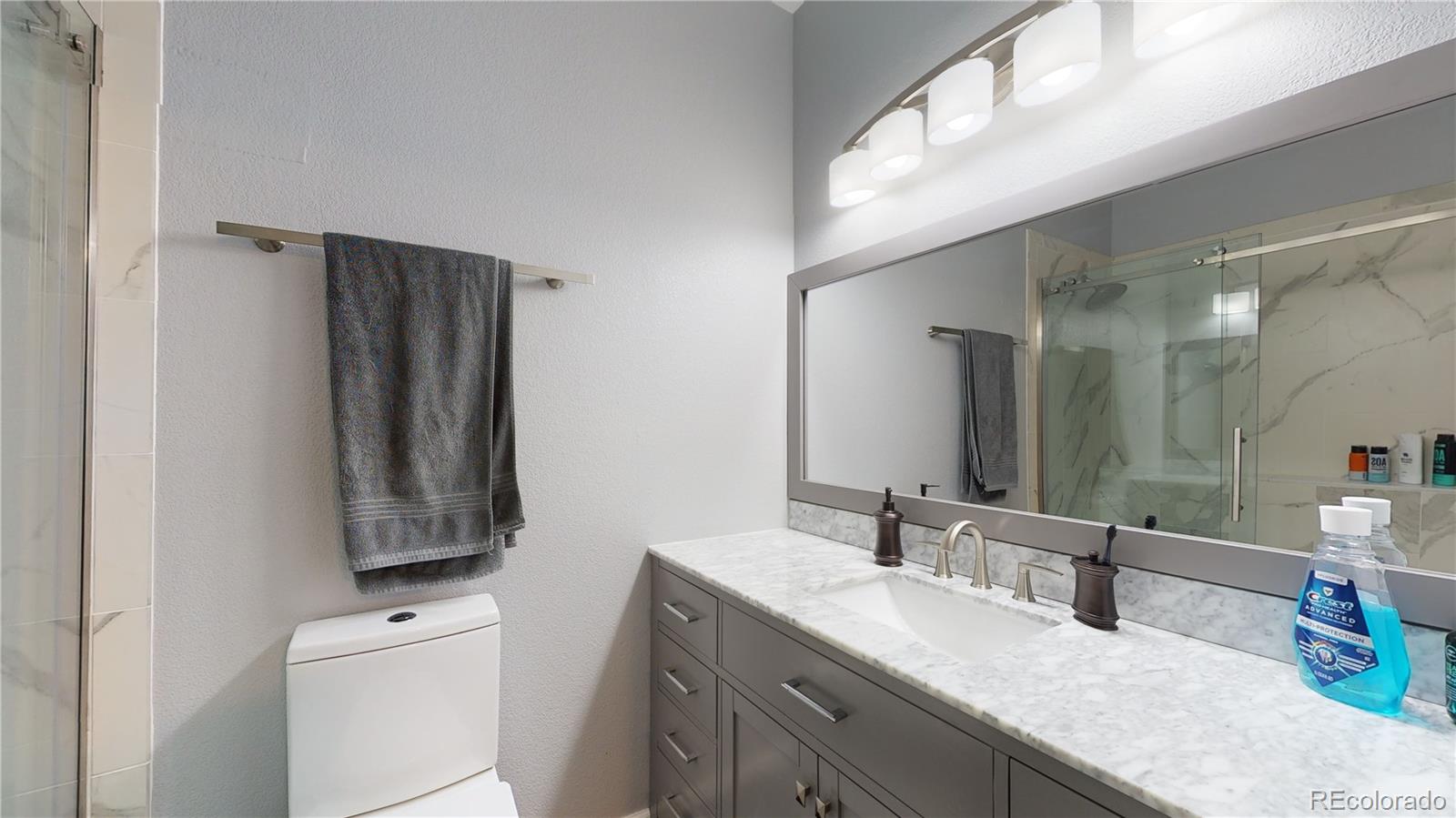 8199 Welby Road, Unit 4001 Denver, CO 80229 - Photo 15 of 24 a bathroom with a granite countertop sink and a mirror