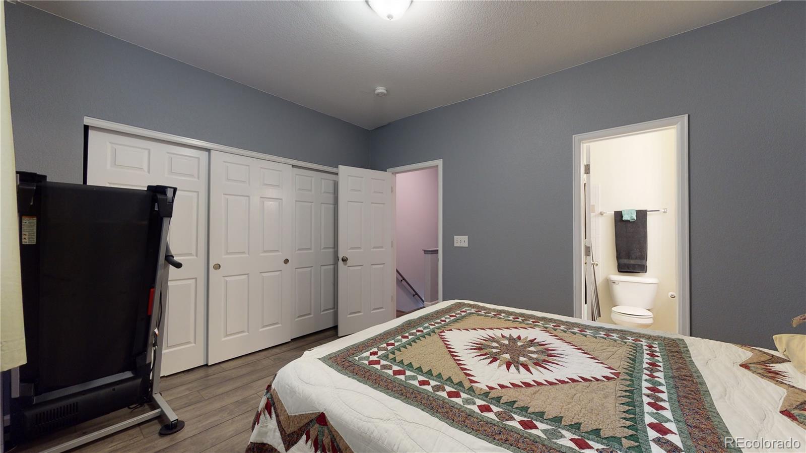 8199 Welby Road, Unit 4001 Denver, CO 80229 - Photo 16 of 24 a bedroom with a bed and a mirror