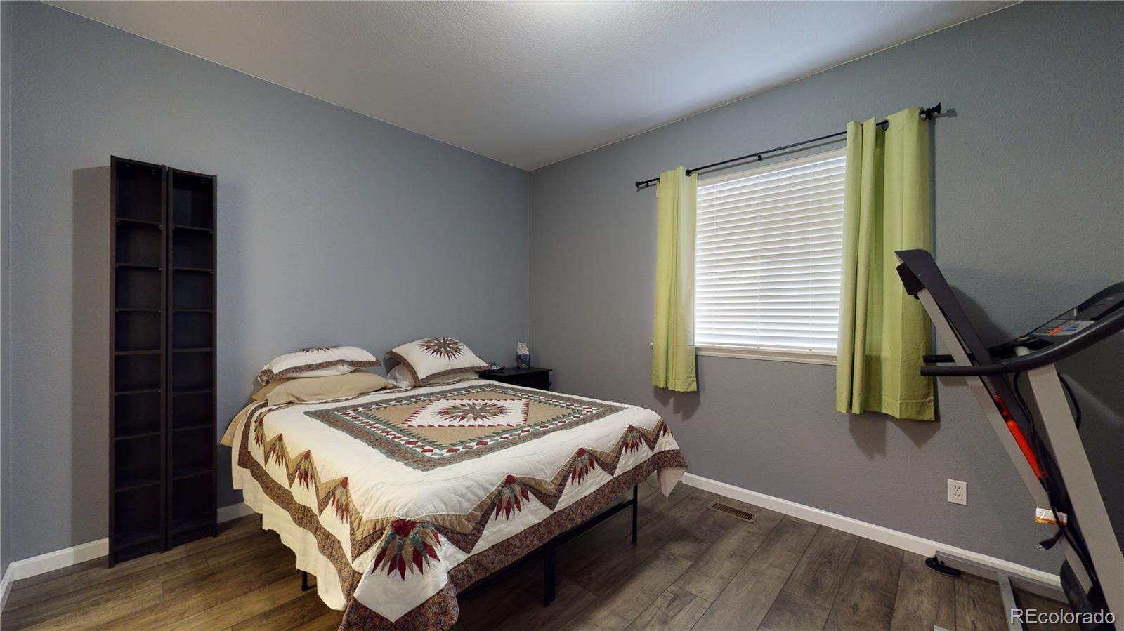 8199 Welby Road, Unit 4001 Denver, CO 80229 - Photo 18 of 24 a bed sitting in a bedroom next to a window