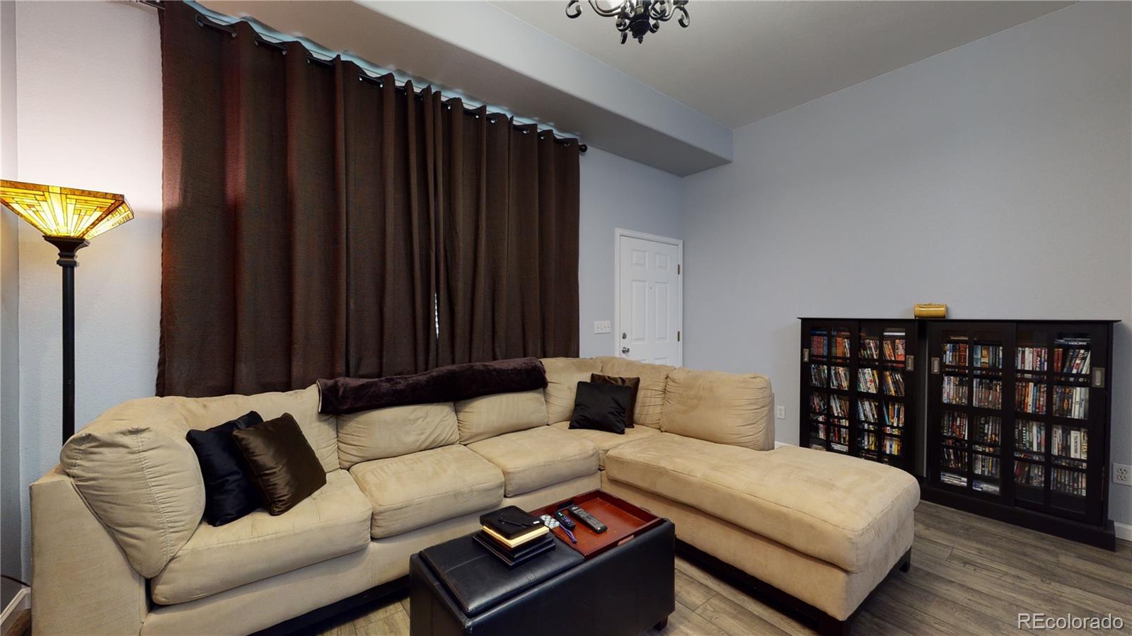 8199 Welby Road, Unit 4001 Denver, CO 80229 - Photo 3 of 24 a living room with furniture and a book shelf