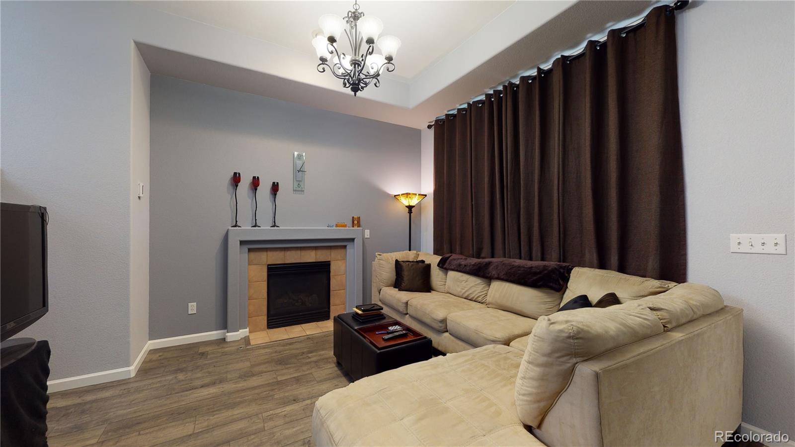 8199 Welby Road, Unit 4001 Denver, CO 80229 - Photo 4 of 24 a living room with furniture a fireplace and a flat screen tv