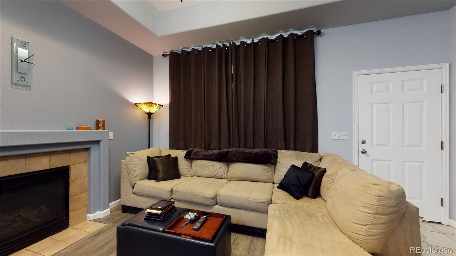 8199 Welby Road, Unit 4001 Denver, CO 80229 - Photo 5 of 24 a bed room with a bed a couch and a fireplace