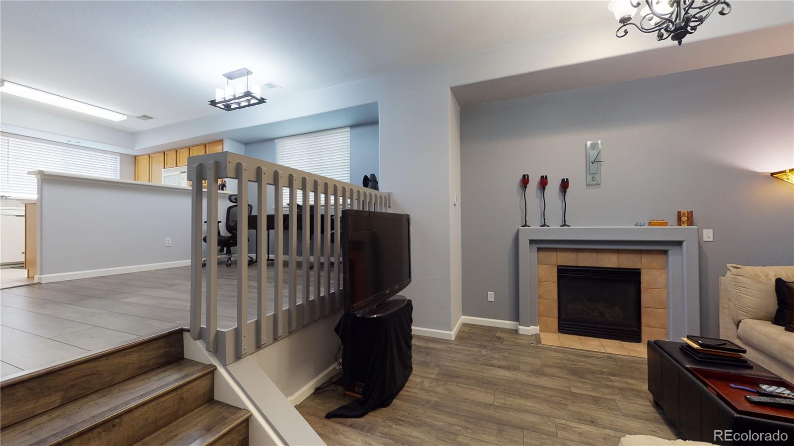 8199 Welby Road, Unit 4001 Denver, CO 80229 - Photo 6 of 24 a view of an empty room with wooden floor fireplace and a window