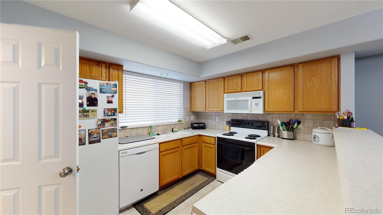 8199 Welby Road, Unit 4001 Denver, CO 80229 - Photo 7 of 24 a kitchen that has a sink and a stove in it