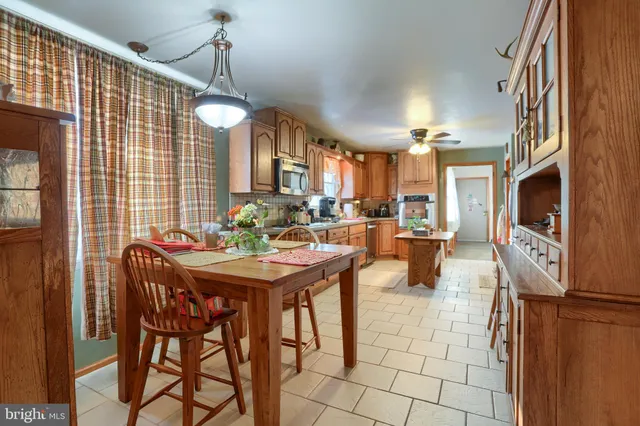 a view of a dining room and livingroom with furniture wooden floor a chandelier