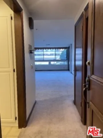 a view of a hallway with closet and window
