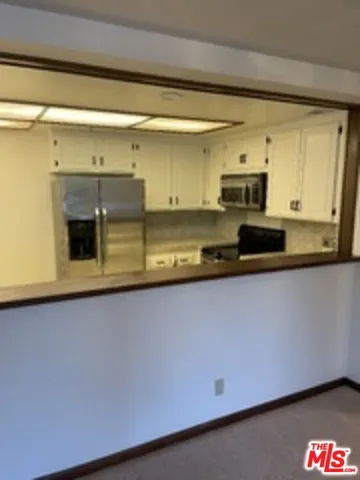 a kitchen with stainless steel appliances a sink a stove and a microwave