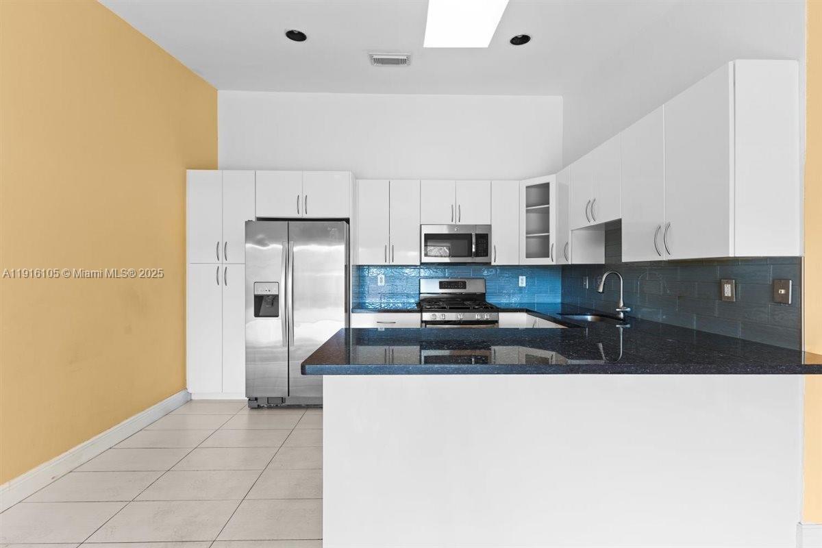 9231 Southwest 150th Avenue Miami, FL 33196 - Photo 15 of 51 a kitchen with stainless steel appliances a sink a stove a microwave a refrigerator a cabinets and wooden floor
